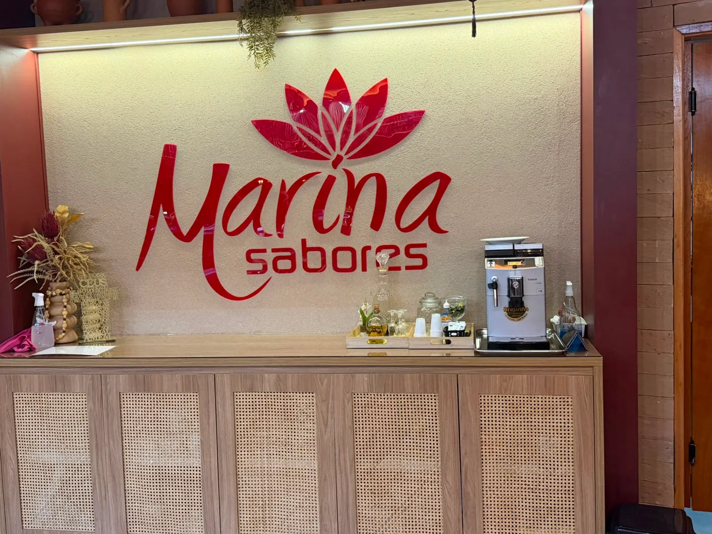 Recepção — Logotipo do Marina Sabores em relevo na parede